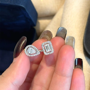 Detailed close-up of a minimalist silver open ring with pear and emerald cut zircon stones
