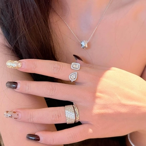 Detailed view of a minimalist zircon open ring with teardrop and square stones