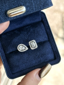 Detail view of minimalist open ring with pear and emerald cut zircon stones in a blue box