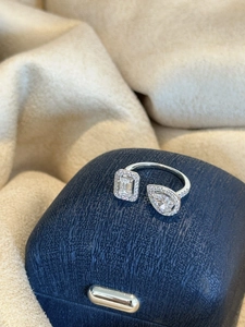 Detail shot of an elegant silver open ring with pear and emerald cut cubic zirconia stones.