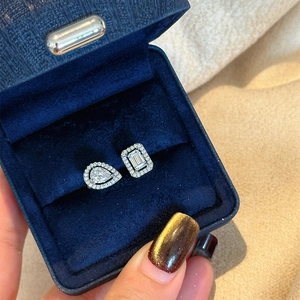 Macro view of an elegant open ring featuring teardrop and emerald-cut stones in a blue box