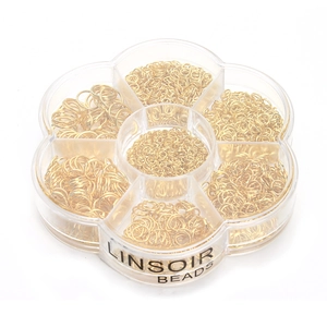 Macro shot of 7-compartment petal box filled with golden jump rings for jewelry DIY