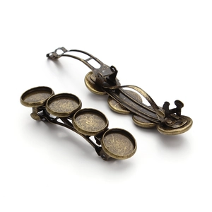 Detail view of two antique bronze metal hair clips with four round DIY bezel trays