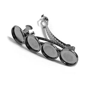 Macro detail of gunmetal hair clip with four round bezel settings for DIY crafting