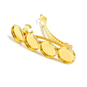 Macro detail of golden spring hair clip base with four round settings for DIY jewelry making
