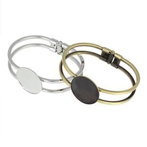 Detail view of vintage 25mm round bezel trays on silver and bronze open bangle bases
