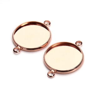 Macro view of two rose gold round connector bezel trays for DIY jewelry making