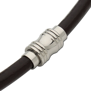 Macro detail of stainless steel magnetic clasp with ridges on dark brown leather cord