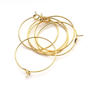 Detailed view of multiple golden round metal wire wine glass charms and earring DIY loops