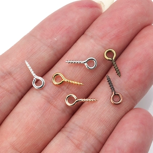 Macro shot of assorted screw eye pins for jewelry making in five metallic finishes