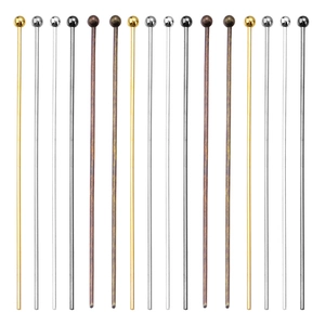 Close-up of assorted metal ball head pins in gold, silver, black, and bronze finishes