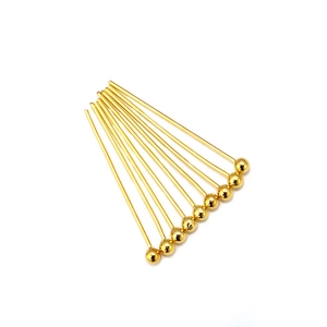 Detailed view of ten gold-plated copper ball head pins for DIY jewelry making