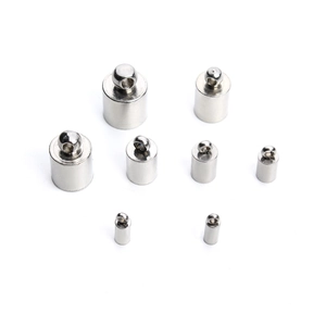 Detailed macro view of 8 different sizes of polished stainless steel end caps for cord jewelry