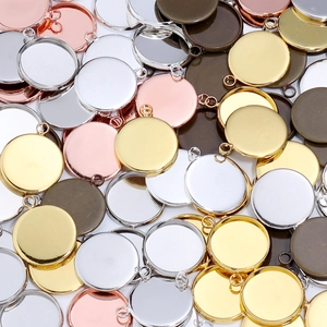Close-up of circular metal pendant trays in silver, gold, and bronze for DIY jewelry making