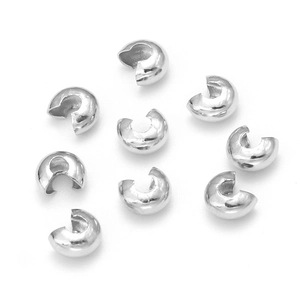Makroaufnahme von versilberten C-förmigen Quetschperlen-Abdeckungen für DIY-Schmuck