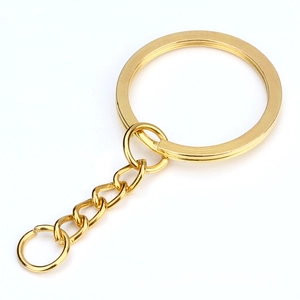 Detalle de llavero plano dorado con cadena y conector para accesorios de artesanía
