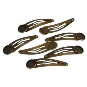 Detail of bronze metal hair clips with round base pads for handmade DIY jewelry