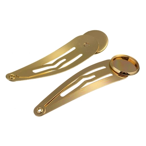 Close-up of golden metal snap hair clips with round base pads for DIY craft accessories