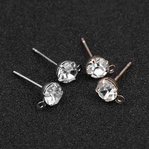 Detail van zilveren en roségouden zirkonia oorknopjes met kleine ophanglussen voor DIY-sieraden