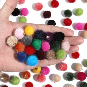 Gedetailleerd zicht op kleurrijke imitatiebont pompoms met gouden ringen voor DIY sieraden
