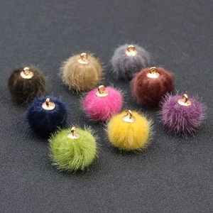 Detail van veelkleurige faux fur pompons met gouden metalen lussen voor DIY-sieraden