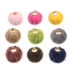 Detailoverzicht van gekleurde nepbonte pompons met gouden kappen voor DIY sieraden maken
