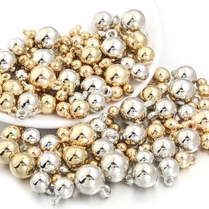 Gros plan de pendentifs ronds en métal doré et argenté avec une finition miroir brillante