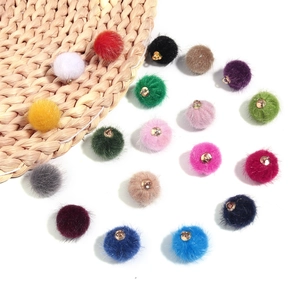 Bovenaanzicht van 16-kleurige faux fur pompon bedeltjes met gouden ringen voor sieraden