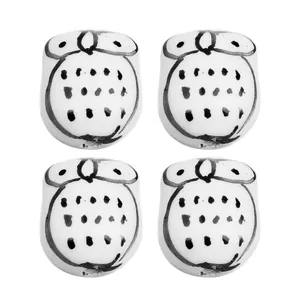 Macro shot of 4 hand-painted white ceramic owl beads for DIY jewelry making and crafts