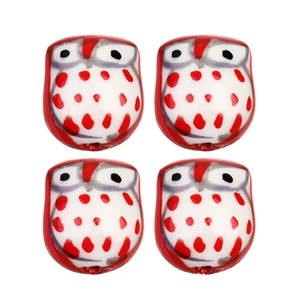 Détail macro de quatre perles hibou en céramique peintes à la main pour bijoux DIY