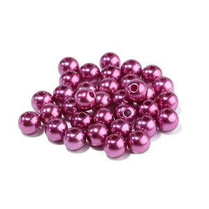 Close-up of bright purple ABS imitation pearls with holes for DIY jewelry making