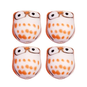 Détail de quatre perles chouettes en céramique faites main avec points orange pour bijoux