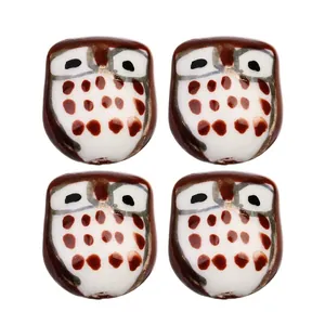 Detail of four hand-painted ceramic owl beads for DIY jewelry making and crafts