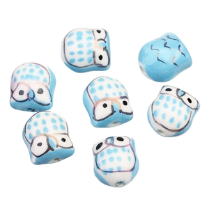 Vue détaillée de perles hibou en céramique bleue peintes à la main pour bijoux DIY