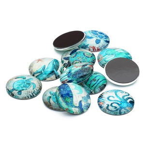 Detailed macro view of ocean-themed glass cabochons with sea turtle and whale patterns