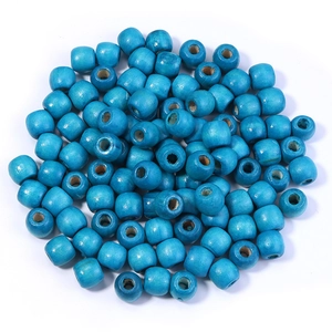 Gros plan de perles en bois d'érable bleu vif avec trous pour la création de bijoux DIY