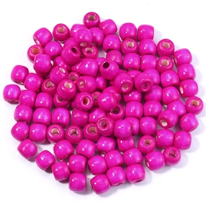 Vue macro de perles cylindriques en bois d'érable rose foncé avec de grands trous pour DIY
