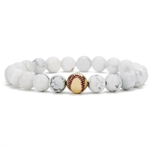 Detail von weißen Türkisperlen mit baseballförmigem Goldmetall-Charm auf elastischem Armband