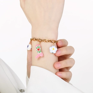 Close-up of a vintage Western cowboy style charm bracelet with colorful enamel boots and flowers
