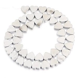 Polished silver heart-shaped loose beads arranged in a spiral for DIY jewelry making