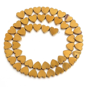 Detail shot of golden heart-shaped beads for DIY jewelry with a matte plating finish