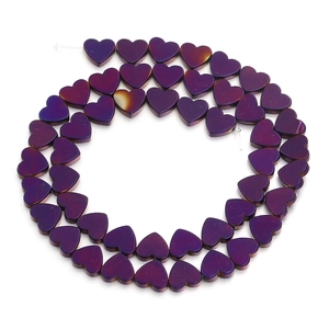 Macro shot of iridescent purple heart-shaped beads for DIY jewelry making and bracelets