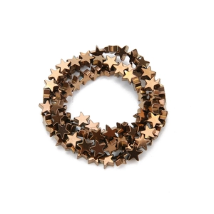 Macro view of star-shaped hematite beads with vacuum plated bronze metallic finish for DIY