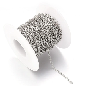 Macro shot of silver 2mm O-shaped metal jewelry chain on a white spool for DIY crafting