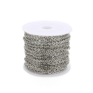 Close-up of shiny silver cross chain roll on white plastic spool for DIY jewelry making