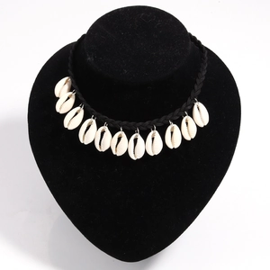 Detail of bohemian choker featuring thirteen natural white shells on a black woven cord
