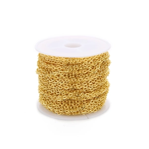 Detail of high-polished gold plated iron cable chain on white spool for DIY jewelry