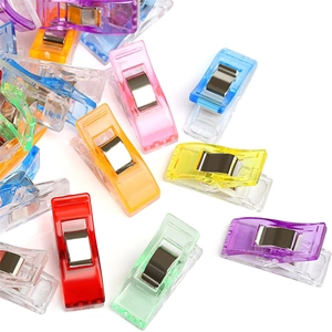 Detailed macro view of colorful semi-transparent plastic sewing clips with metal springs