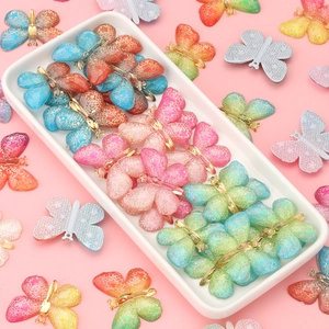 Detailed view of colorful acrylic butterfly charms with glitter resin and gold metal clips