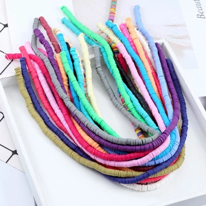 Bunte Heishi-Perlen aus Polymer-Ton für DIY-Schmuck auf weißem Holztablett
